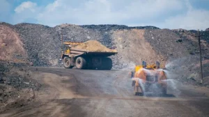 Water spray nozzles suppressing dust on a mine haul road as a truck passes